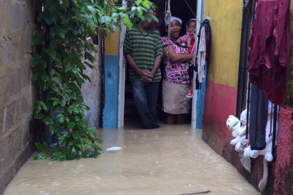 Family standing in flooded alleyway entrance.