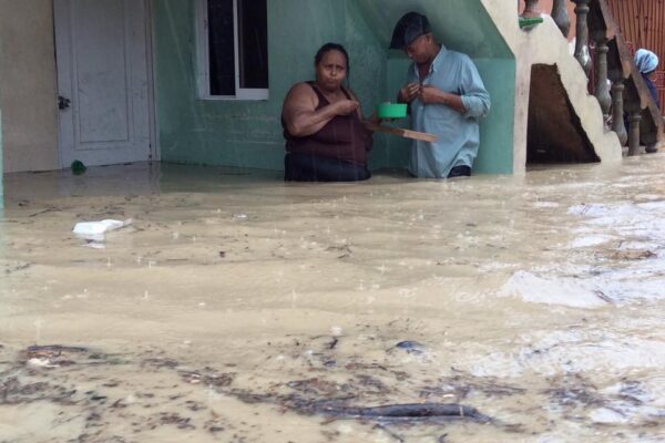 People standing in flooded house during storm.