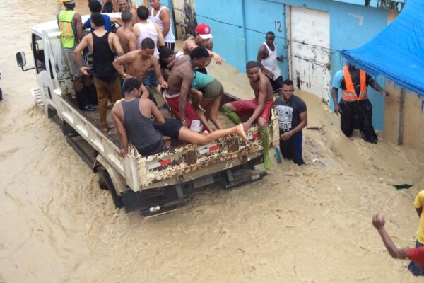 People evacuate on truck during urban flood waters.