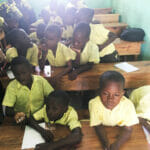 Children in classroom wearing yellow shirts.