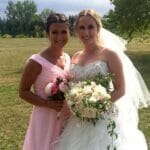 Bride and bridesmaid posing outdoors with bouquets