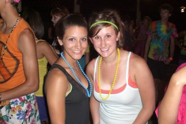 Two smiling women at a colorful party.