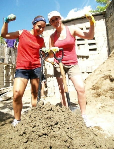 Women volunteering, shoveling dirt, outdoor construction project