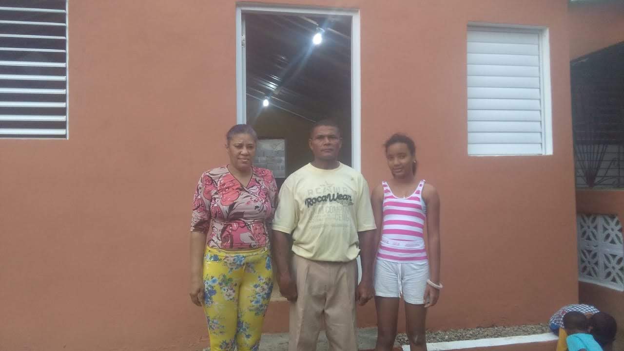 Family standing in front of orange house