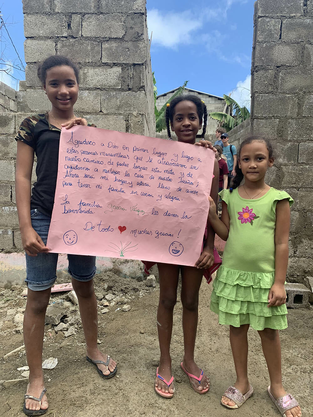 Three children holding a thank you note.