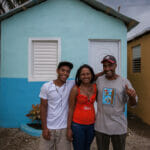 Smiling family in front of colorful house