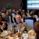People clapping at a formal dinner event