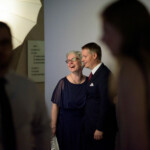 Smiling couple at an event with lighting setup.