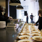 Caterers preparing dishes at an event with music.