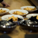 Plates of cheese fries on wooden table.